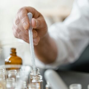 Detailed image of a person mixing essential oils in a laboratory setting.