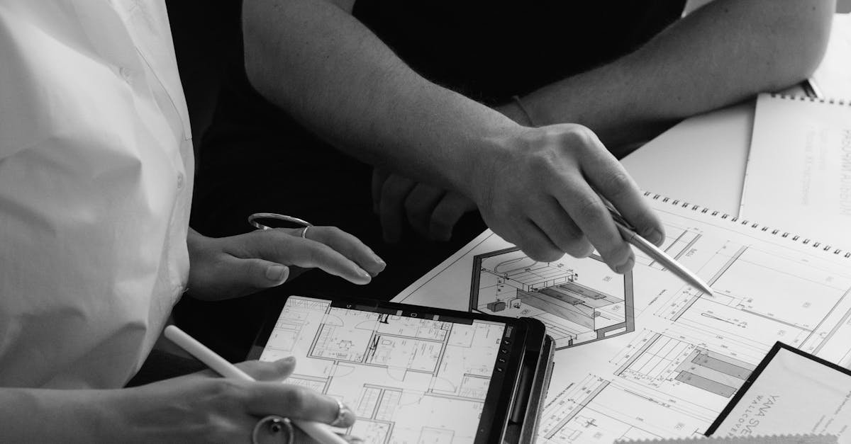 pexels photo 20279561 20279561 Black and white photo of architects discussing project plans using digital tablets and paper documents.