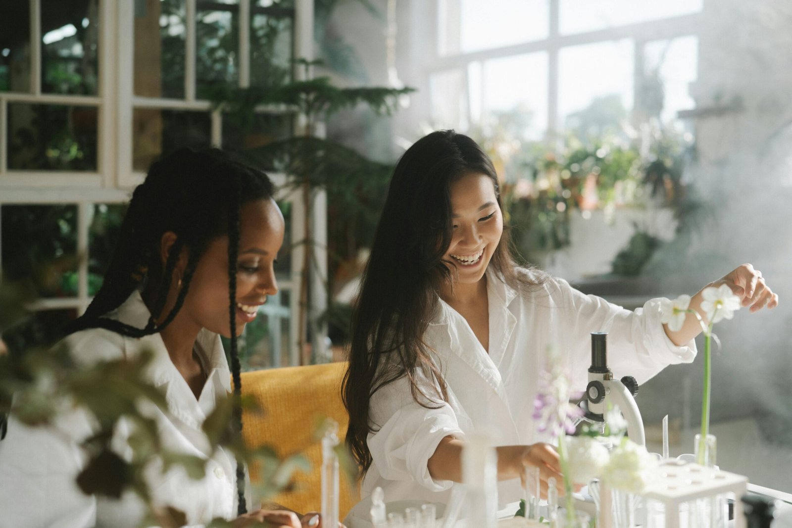 zipwp image 8515123 Two women scientists happily engage in botanical research in a bright, indoor lab setting.